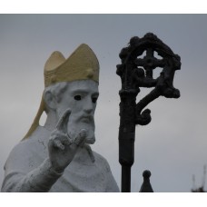 Statue holding a crosier, solar cross, solar disc, mitre